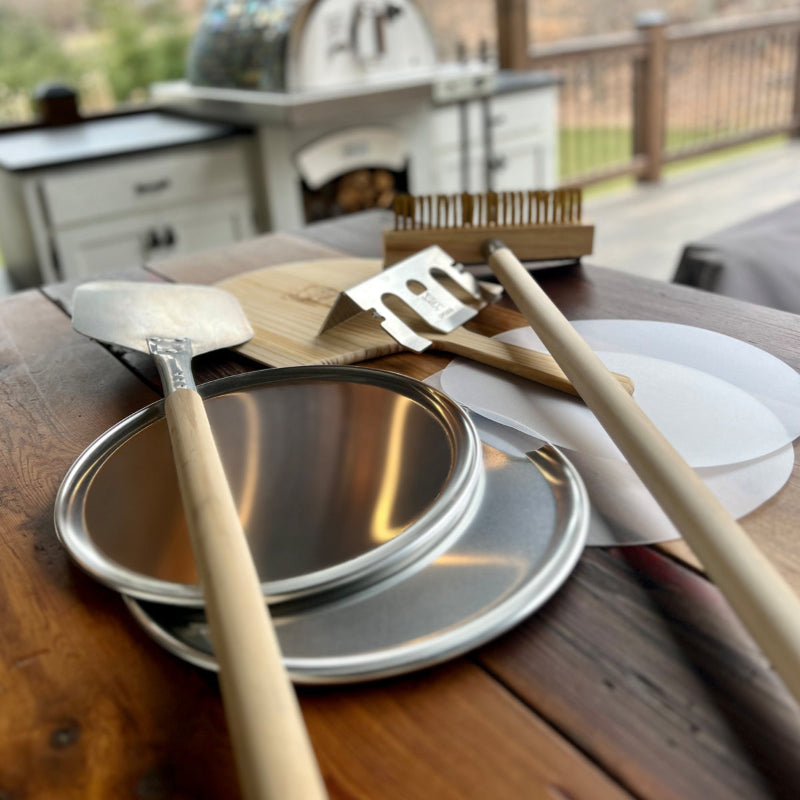 Outdoor setting with metal pans and wooden utensils on a table